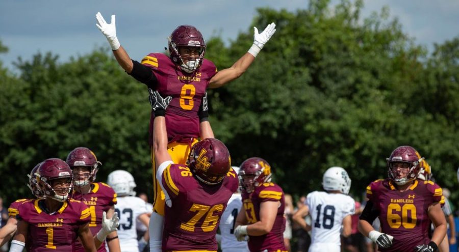 Senior Christo Kelly lifts of senior Trevor Cabanban in celebration of his touchdown over New Trier. Cabanban's touchdown was just one of many in the Rambler romp over New Trier. 