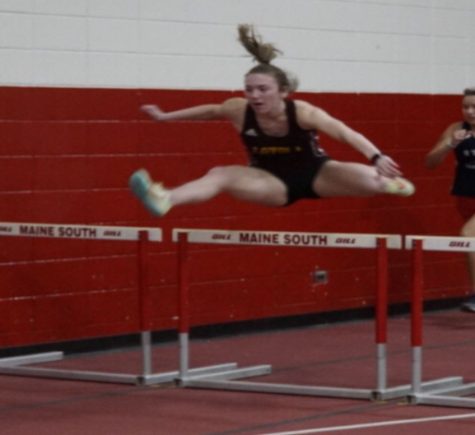 Makena Coltoff leaps over a hurdle in the 50M hurdle race during the indoor track season.