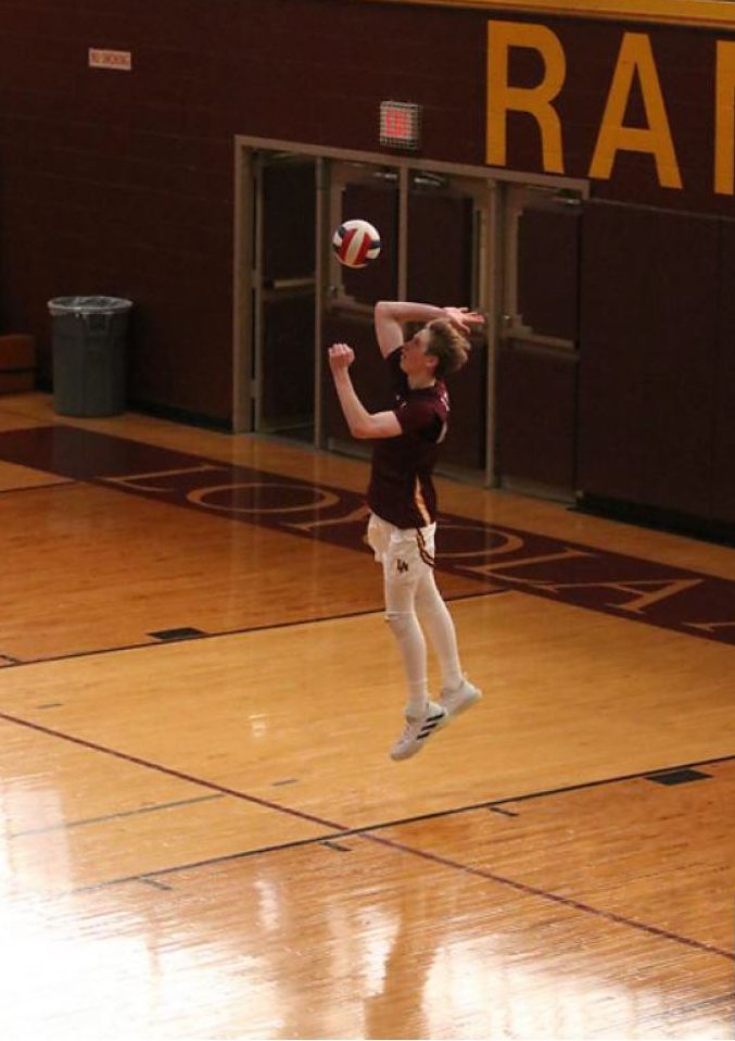 Senior libero Stef Kins floats in the air as he serves to the defending St. Rita Mustangs in hopes for an ace. The Ramblers won easily in two sets. 