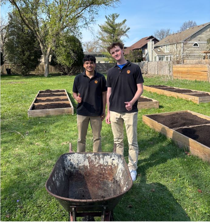 Honors Environmental Science Service Learning students Brandon Matejka and Diego Fernandez help move soil into the garden beds.